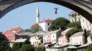Aksi seorang peserta pria melompat dari jembatan saat mengkuti acara kompetisi menyelam tradisional 450 di Mostar, Bosnia dan Herzegovina, (31/7). (REUTERS/Dado Ruvic)