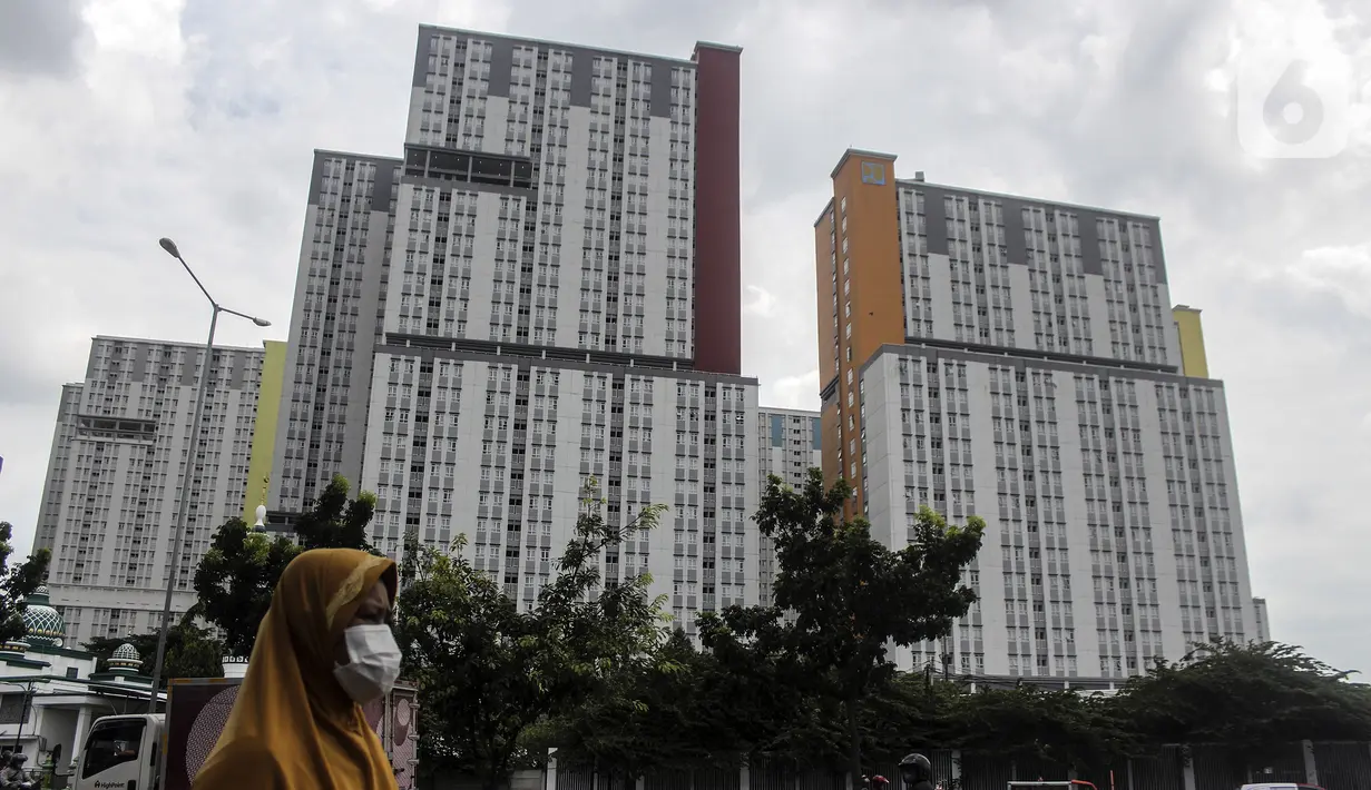Seorang warga berjalan dekat tempat karantina pasien COVID-19 Wisma Atlet, Jakarta, Kamis (3/3/2022). Hingga dua tahun berselang, pada 2 Maret 2022, pemerintah mencatat ada 5.630.096 kasus positif COVID-19 di Indonesia sejak pengumuman kasus pertama. (Liputan6.com/Johan Tallo)