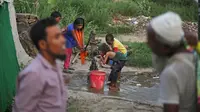 Sejumlah anak pengungsi Rohingya mengisi air dari pompa di sebuah kamp pengungsi di New Delhi, India (12/9). Pengungsi Rohingya di India diancam pemerintah untuk dideportasi kembali ke Myanmar. (AP Photo/Altaf Qadri)
