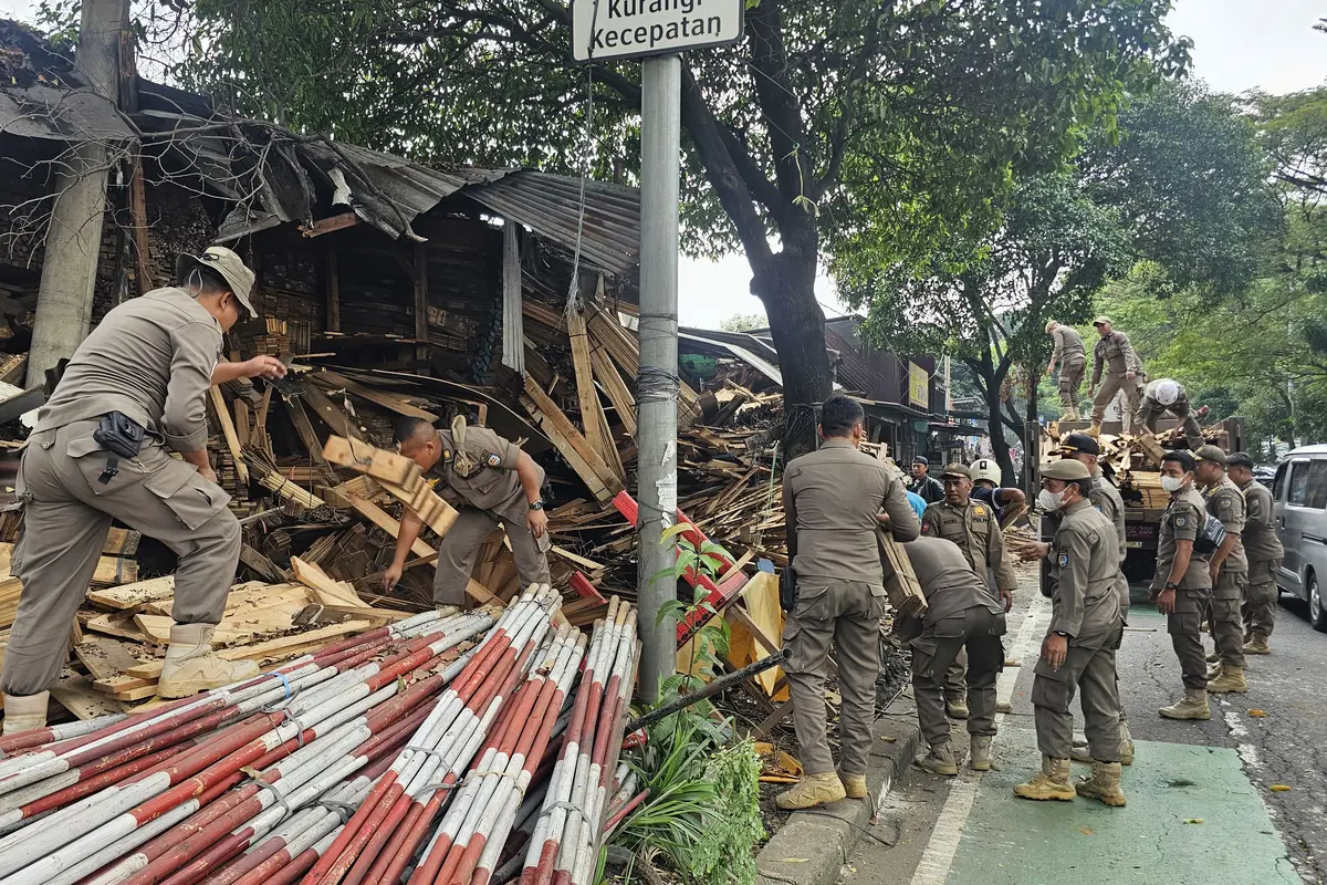 Satpol PP Kota Depok menertibakan bangunan liar di Jalan Raya Juanda, Depok.