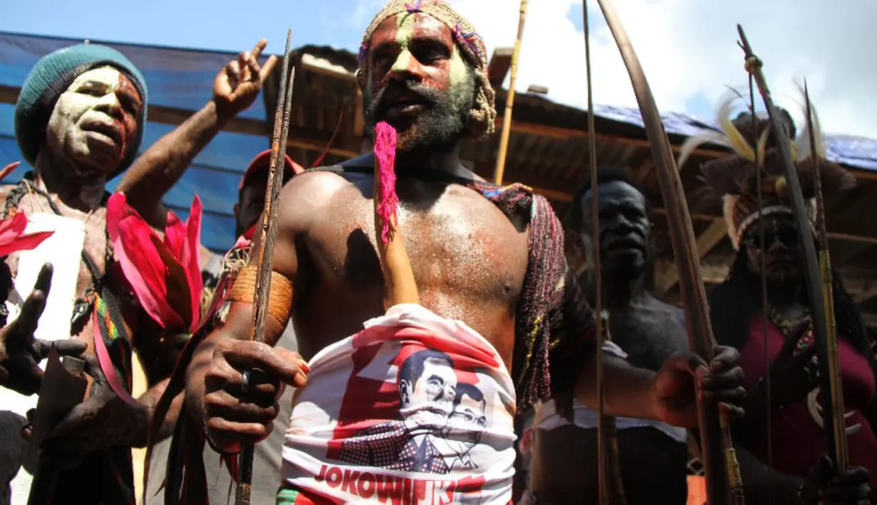 Salah satu warga Papua tampak menggunakan balutan kain yang bertuliskan Jokowi-JK. (AFP PHOTO / Liva Lazore)