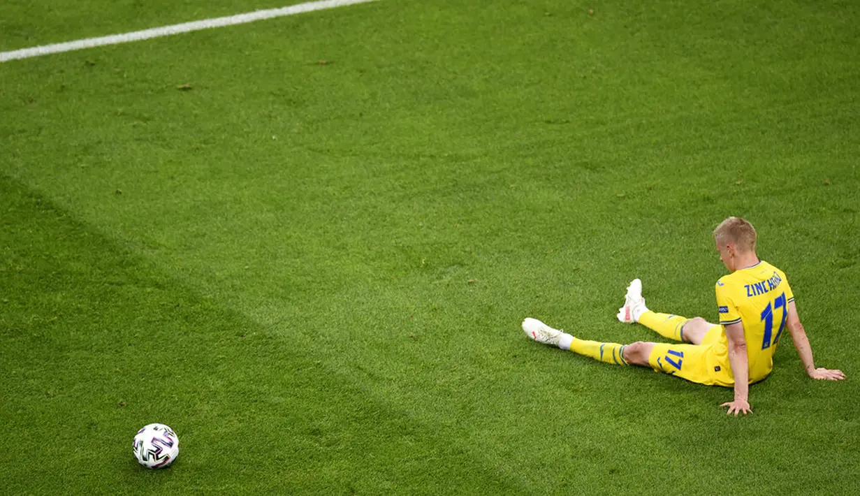Pemain Ukraina Oleksandr Zinchenko terduduk di lapangan usai menghadapi Austria pada pertandingan Grup C Euro 2020 di Stadion National Arena, Bucharest, Rumania, Senin (21/6/2021). Ukraina kalah 0-1. (Mihai Barbu/Pool Photo via AP)