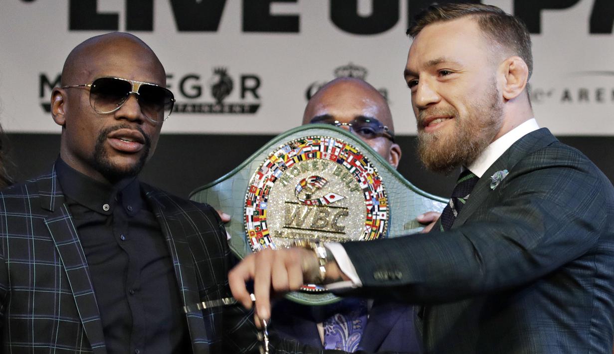 Floyd Mayweather Jr. (kiri) dan Conor McGregor bersiap untuk foto bersama usai konferensi pers di MGM Grand, Las Vegas, (23/8/2017). Mereka akan bertarung pada 26 Agustus 2017 atau Minggu pagi. (AP/John Locher)