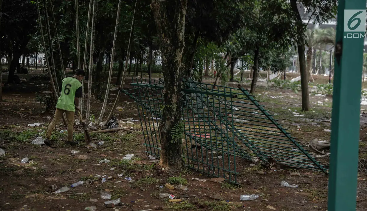 Petugas membersihkan sampah dekat pagar tanaman yang dirusak pada Final Piala Presiden 2018 di Stadion Utama GBK, Jakarta, Minggu (18/2). Laga antara Persija Jakarta vs Bali United menyisakan kerusakan di dalam dan luar GBK. (Liputan6.com/Faizal Fanani)