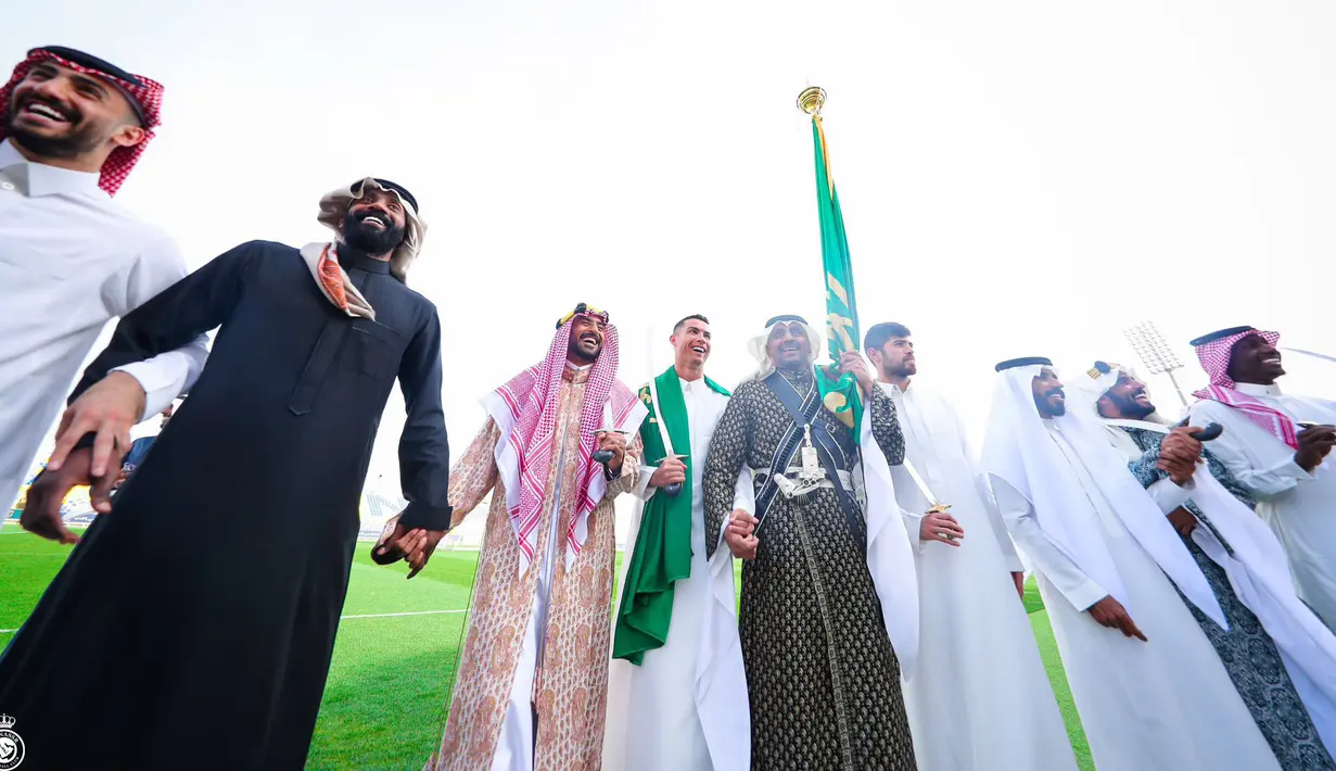 Pemain Al-Nassr, Cristiano Ronaldo (tengah) memakai gamis dan membawa pedang saat memperingati Hari Pendirian Kerajaan Saudi atau Founding Day di tempat berlatih pada Rabu (22/02/2023). (Twitter/@AlNassrFC)