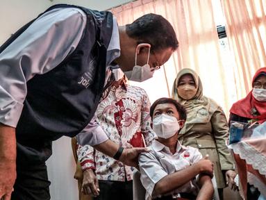 Gunernur DKI Jakarta Anies Baswedan menyapa salah seorang murid saat meninjau hari pertama pelaksanaan vaksinasi COVID-19 untuk anak 6-11 tahun di SDN Cempaka Putih Timur 03 Pagi, Jakarta, Selasa (14/12/2021). (merdeka.com/Iqbal S. Nugroho)