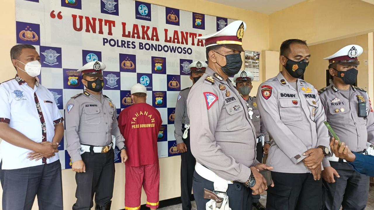 Surahman memakai baju tahan sopir insiden kecelakaan di jalan raya ijen Bondowoso ditetapkan jadi tersangka. (Istimewa)