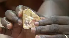 Presiden Ernest Bai Koroma memegang bongkahan berlian mentah 706 karat di kantor kepresidenan di Freetown, Sierra Leone, Kamis (16/3). Berlian besar itu ditemukan seorang pastor, Emmanuel Momoh, di kota kuno Kono, timur negara tersebut. (SLBC via AP)