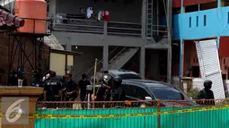 Petugas menggelar olah TKP di rumah terduga anggota jaringan teroris, Bekasi, Minggu (11/12). Densus 88 menangkap tiga orang terduga anggota kelompok teroris dan menemukan bom siap ledak. (Liputan6.com/Johan Tallo)