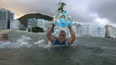 Penganut kepercayaan Afro-Brasil membawa persembahan untuk Dewi Laut, Yemanja dalam tradisi upacara menjelang tahun baru di pantai Copacabana, Rio de Janeiro, Sabtu (29/12). Mereka melarung sesaji sebagai bentuk syukur kepada dewi laut. (AP/Leo Correa)