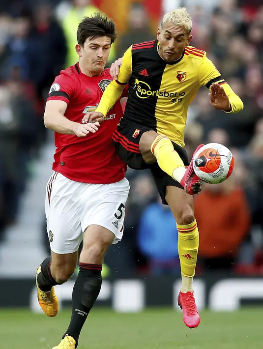 Pemain Manchester United Harry Maguire (kiri) mengejar pemain Watford Roberto Pereyra pada pertandingan Liga Inggris di Old Trafford, Manchester, Inggris, Minggu (23/2/2020). Manchester United menang 3-0. (Martin Rickett/PA via AP)