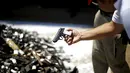 Petugas kepolisian tampak melihat kondisi senjata yang nantinya akan dimusnahkan di di Santiago, Chile, Senin (18/1). Senjata - senjata ini nantinya kan dimusnahkan dengan dilelehkan atau dibakar.  (REUTERS / Ivan Alvarado)