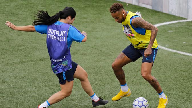Bintang sepak bola Brasil, Neymar (kanan) mencoba menggocek lawan dalam turnamen untuk badan amal Neymar Junior Project Institute di Praia Grande, Sao Paulo, Brasil, Sabtu (21/7). (AP Photo / Nelson Antoine)