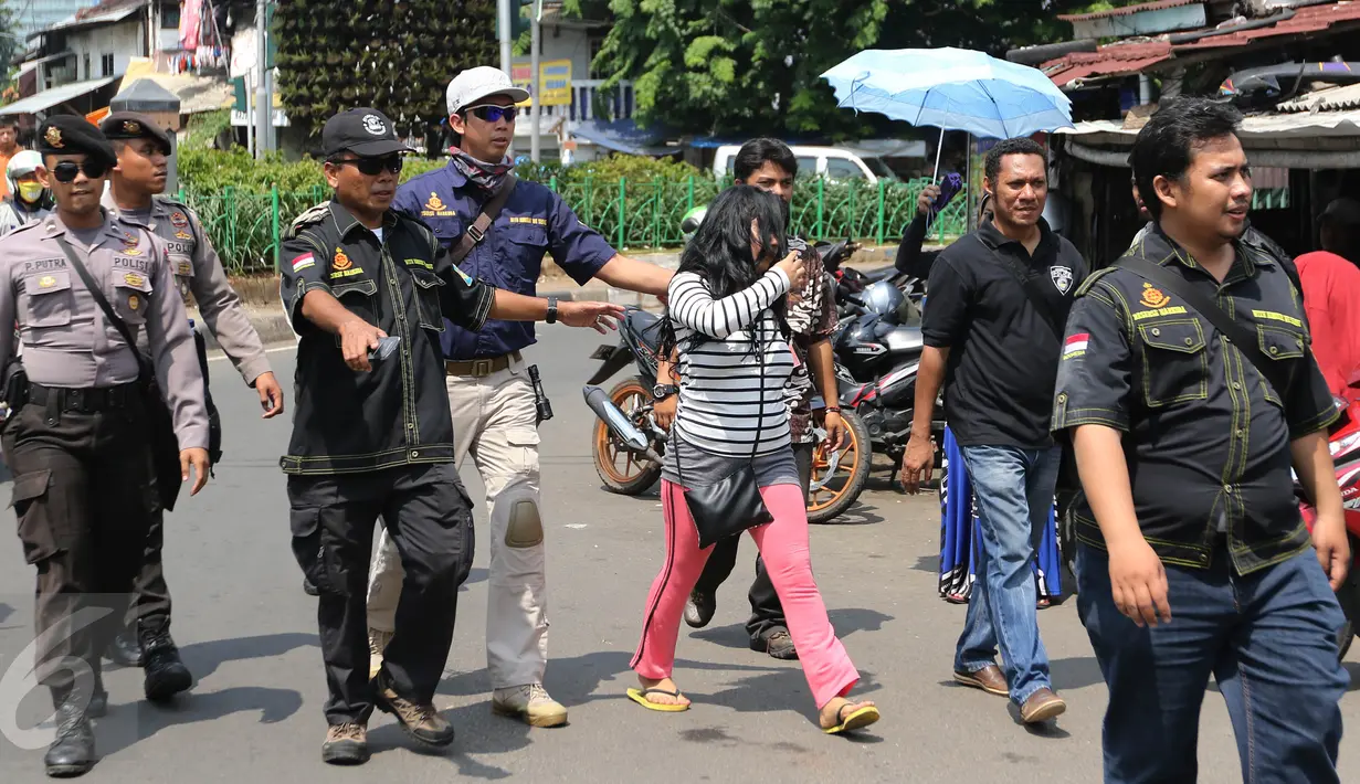 Petugas BNN dan aparat kepolisian mengamankan Warga Negara Asing (WNA) yang terkena razia di kawasan Petamburan, Jakarta, Jumat (29/1). Diduga razia tersebut terkait kasus penggerebekan sabu ratusan kilogram di Jepara. (Liputan6.com/Herman Zakharia)