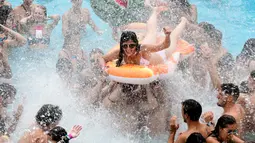 Seorang wanita menaiki ban karet saat berjoget di kolam renang selama Arenal Sound Music Festival 2019 di Burriana, Spanyol (31/7/2019). Festival musik ini berlangsung dari 30 Juli sampai 4 Agustus 2019.  (AFP Photo/Jose Jordan)