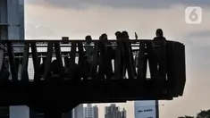 Warga berfoto saat ngabuburit di JPO Pinisi Pinisi Karet-Sudirman, Jakarta Pusat, Senin (4/4/2022). JPO Pinisi kini menjadi destinasi baru warga Jakarta untuk menunggu waktu berbuka puasa atau ngabuburit sambil menikmati suasana perkotaan. (merdeka.com/Iqbal S. Nugroho)