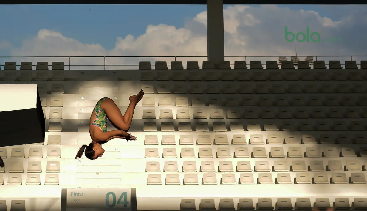 Seorang atlet putri Indonesia melakukan loncatan dengan ketinggian lima meter pada sesi latihan di Aquatic Center, Senayan, Jakarta, Kamis (15/3/2018). Latihan tersebut merupakan persiapan menuju Asian Games 2018. (Bola.com/Nick Hanoatubun)