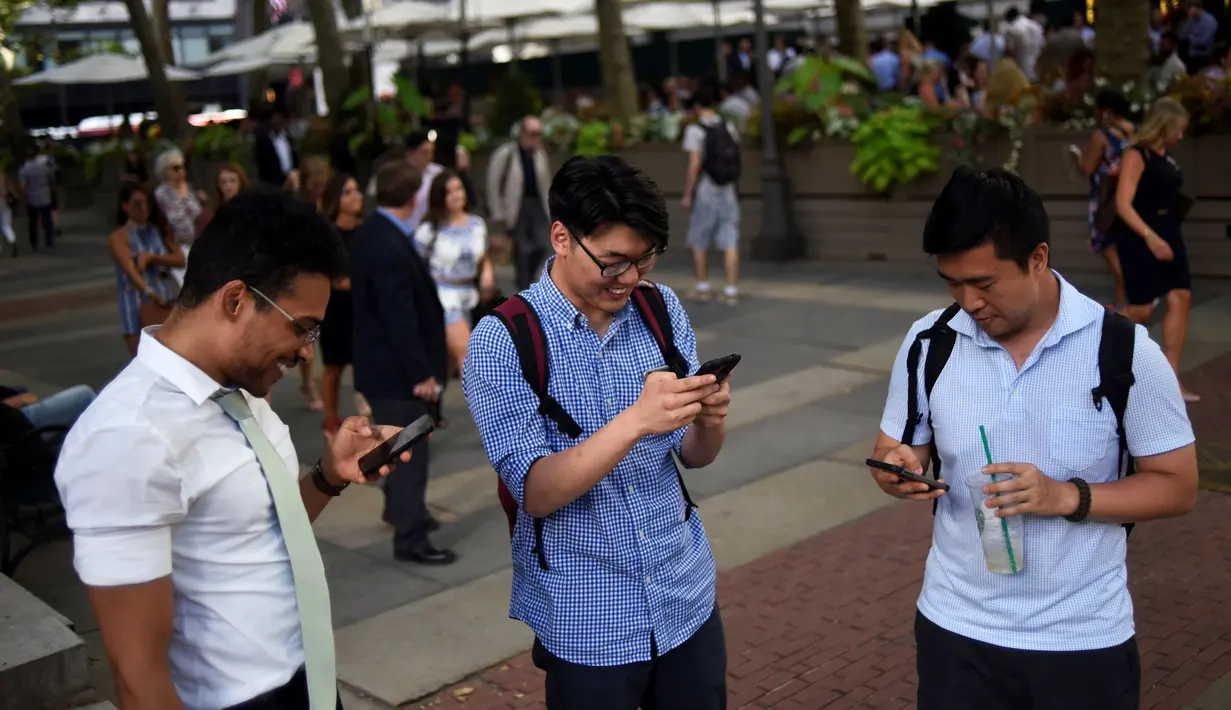 Sejumlah pria asyik bermain augmented reality Pokemon Go di Bryant Park, New York City, Amerika Serikat, 11 Juli 2016. Sejak dirilis, game keluaran Nintendo dan The Pokemon Company itu berhasil menjadi candu para penggunanya. (REUTERS/Mark Kauzlarich)