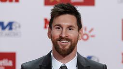 Penyerang Barcelona, Lionel Messi tersenyum usai meraih sepatu emas di Barcelona, Spanyol (24/11). Messi berhasil meraih sepatu emas keempat seperti yang diraih Cristiano Ronaldo. (AP Photo/Manu Fernandez)