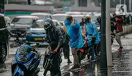 Pengendara motor menggunakan jas hujan saat hujan deras mengguyur kawasan Jalan Thamrin, Jakarta, Selasa (31/5/2022). Potensi cuaca ekstrem di sejumlah wilayah di Indonesia pada hari ini dipengaruhi oleh kemunculan bibit siklon tropis 92S di Samudera Hindia selatan Jawa Barat. (Liputan6.com/Faizal Fanani)
