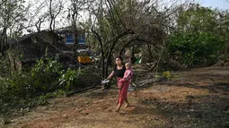 Topan Mocha menerjang daratan Myanmar dan Bangladesh tenggara pada 14 Mei, menumbangkan pepohonan, merobohkan rumah-rumah tipis di kamp-kamp pengungsian Rohingya, dan membawa gelombang badai ke daerah dataran rendah. (Photo by Sai Aung MAIN / AFP)