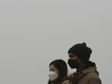 Pasangan mengenakan masker berjalan di Gunung Namsan di Seoul, Korea Selatan (10/12/2019). Korea Selatan telah mengeluarkan langkah-langkah darurat untuk polusi udara, setelah rekor tingkat debu halus menyelimuti sebagian besar negara dalam beberapa pekan terakhir. (AP Photo/Ahn Young-joon)