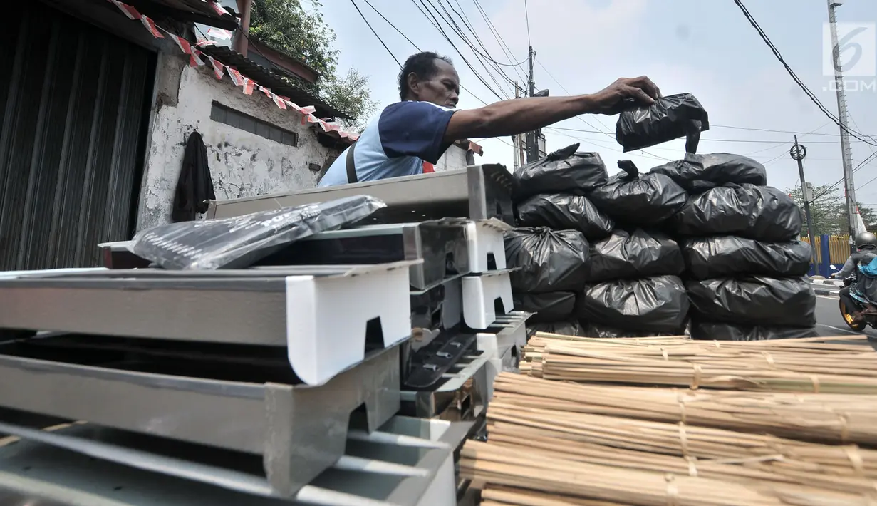 Penjual arang, tusuk sate, dan kotak pemanggang merapikan dagangannya di kawasan Manggarai, Jakarta, Rabu (22/8). Perlengkapan membuat sate dijual mulai dari Rp 5.000 hingga Rp 120.000. (Merdeka.com/Iqbal Nugroho)