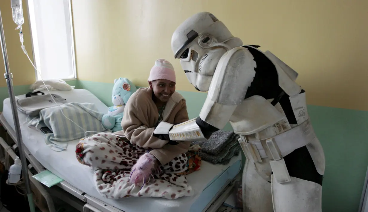 Seorang cosplayer berpakaian Stormtrooper berbincang dengan seorang pasien saat acara amal oleh El Salvador Star Wars fan club di Rumah Sakit Benjamin Bloom Anak Nasional di San Salvador, El Salvador (14/12). (REUTERS/Jose Cabezas)