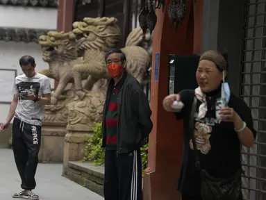 Warga beraktivitas di dekat singa batu di Yu Garden Mall di Shanghai (2/6/2022). Lalu lintas, pejalan kaki dan pelari muncul kembali di jalan-jalan Shanghai ketika kota terbesar di China mulai kembali normal di tengah pelonggaran penguncian COVID-19 dua bulan yang ketat atas penerapannya. (AP Photo/Ng Han Guan)