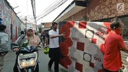 Warga berusaha menyelamatkan harta benda mereka ketika kebakaran melanda permukiman padat penduduk di Manggarai, Jakarta, Rabu (10/7/2019). Hingga saat ini sebanyak 28 unit mobil pemadam kebakaran dikerahkan di lokasi kejadian yang tak jauh dari Stasiun Kereta Api. (Liputan6.com/Herman Zakharia)