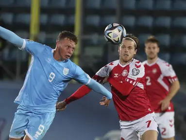 Gelandang Denmark Mathias Jensen berebut bola dengan penyerang Nicola Nanni dalam matchday kedelapan  Kualifikasi Euro 2024 Grup H di Stadion San Marino di Serravalle, Rabu (18/10/2023) dini hari WIB. (AP Photo/Felice Calabro)