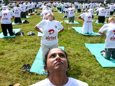Ratusan warga melakukan gerakan yoga saat mengikuti sesi yoga massal di Stadion Afraha di Nakuru, Kenya (15/6/2019). Acara yoga massal ini untuk memperingati Hari Yoga Internasional. (AFP Photo/Suleiman Mbatiah)