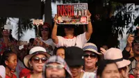 Penonton membawa poster saat hadir dalam Konser Kebangkitan Nasional di Waduk Pluit, Penjaringan, Jakarta Utara, Sabtu (20/5). (Liputan6.com/Gempur M. Surya)