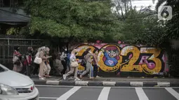Sejumlah pekerja beraktivitas di jalur pedestrian Jalan Thamrin, Jakarta, Kamis (5/1/2023). Pencabutan Pemberlakuan Pembatasan Kegiatan Masyarakat (PPKM) dinilai untuk menggenjot ekonomi Indonesia 2023 yang diproyeksi suram akibat resesi global. (Liputan6.com/Faizal Fanani)