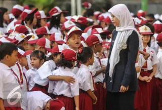 Guru mengatur para murid sebelum upacara di SD Pasar Baru 05, Jakarta, Senin (27/7/2015). Usai libur panjang Idul Fitri para siswa kembali beraktivitas mengikuti pelajaran di sekolah untuk tahun ajaran 2015-2016. (Liputan6.com/Faizal Fanani)