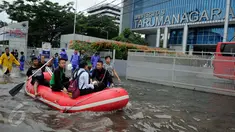 Warga menggunakan perahu karet melintasi banjir yang merendam Jalan S Parman, di depan Universitas Tarumanagara (Untar), Jakarta, Selasa (21/2). Banjir di kawasan ini disebabkan meluapnya beberapa sungai di Jakarta Barat. (Liputan6.com/Gempur M Surya)