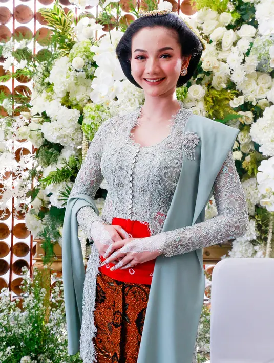 Kebaya karya Renzi Lazuardi tersebut dilengkapi stagen warna merah motif jumputan, serta selendang yang disematkan dengan bros pada salah satu bahunya. [Dok/KapanLagi].
