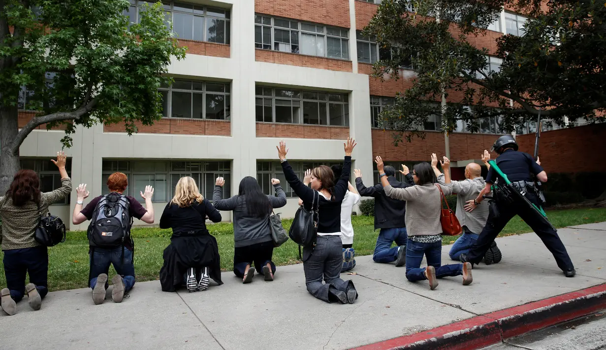 Petugas memeriksa sejumlah orang menyusul penembakan di Universitas California Los Angeles (UCLA), Rabu (1/6). Insiden itu memicu penutupan kampus dan memaksa ratusan mahasiswa yang ketakutan bersembunyi di dalam gedung. (REUTERS/Patrick T. Fallon)