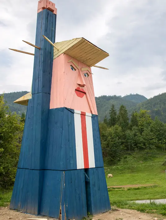 Sebuah patung kayu yang menyerupai Donald Trump didirikan di Sela pri Kamniku, kawasan utara Slovenia, 30 Agustus 2019. Patung Trump setinggi 8 meteritu mengenakan setelan biru, kemeja berwarna putih, dasi merah, serta mengangkat tangan seperti Patung Liberty. (AP/Darko Bandic)