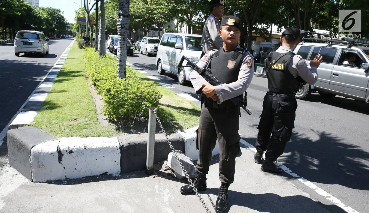 Petugas kepolisian bersiaga di sepanjang jalur yang dilalui rombongan Barack Obama menuju Base Ops Lanud Ngurah Rai, Bali, Rabu (28/6). Obama dan keluarga meninggalkan Bali untuk melanjutkan liburan ke Yogyakarta. (Liputan6.com/Immanuel Antonius) 