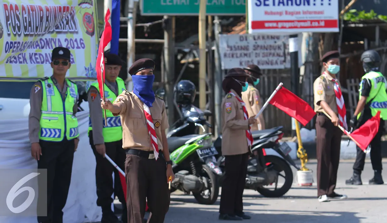 Para anggota pramuka mengatur lalu lintas jalur mudik di Cirebon, Jawa Barat, Jumat (1/7). Sebanyak 3.000-4.000 anggota pramuka Kwartir Daerah dikerahkan untuk membantu polisi dalam memberikan pelayanan kepada para pemudik. (Liputan6.com/Angga Yuniar)