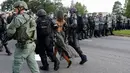 Seorang wanita dibawa Polisi saat melakukan aksi protes di dekat markas Kepolisian Rouge Baton di Baton Rouge, AS (9/7). Warga AS keturunan Afrika berdemonstrasi karena ada warga kulit hitam yang mati ditembak polisi. (REUTERS / Jonathan Bachman)