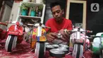 Perajin Ogifson Harianja, menyelesaikan miniatur vespa dari kaleng bekas, Jakarta, Jumat (7/1/2022). Pemerintah melalui Kemenko Perekonomian telah mengumumkan bahwa plafon penyaluran KUR 2022 ditingkatkan menjadi Rp373,17 triliun, dengan suku bunga tetap sebesar 6 persen. (Liputan6.com/Angga Yuniar)