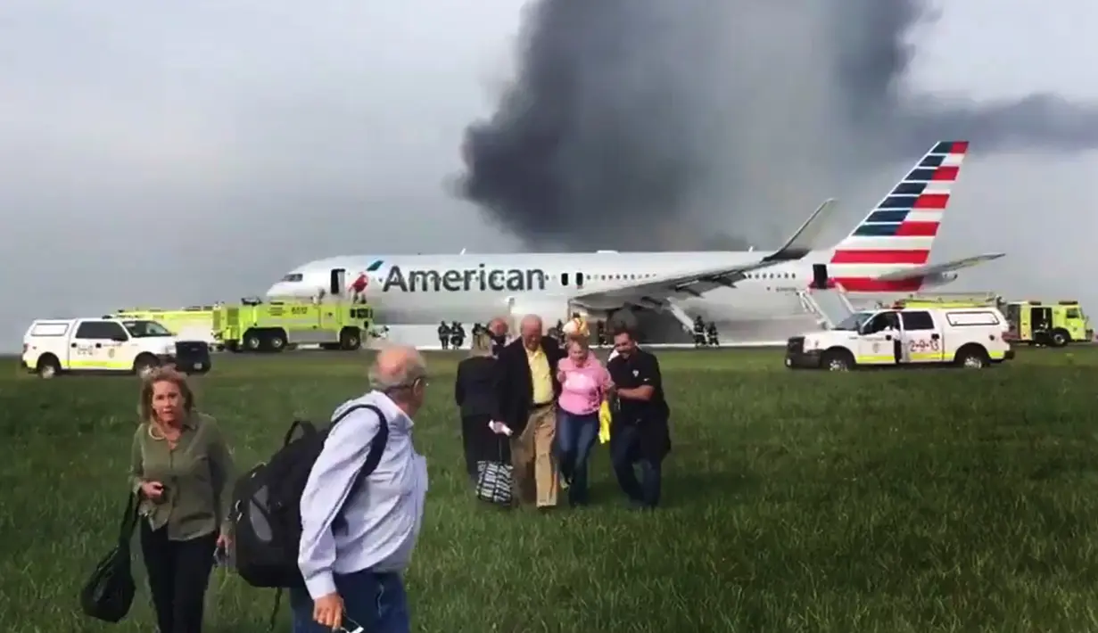 Sejumlah penumpang dievakuasi  saat pesawat American Airlines yang terbakar di Bandara O'Hare Chicago, Illinois, AS (28/10). (Jose Castillo via AP)