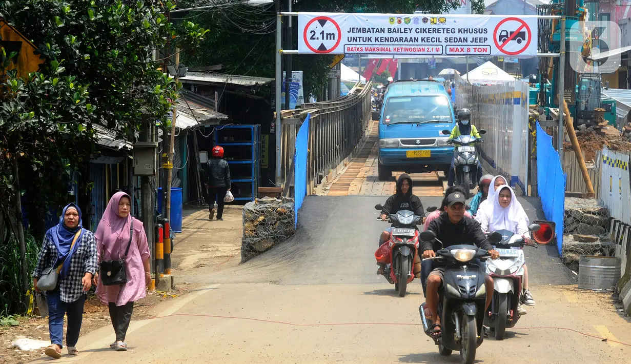 Pengguna jalan melintasi jembatan darurat atau bailey Cikereteg di Jalan Raya Bogor-Sukabumi, Bogor, Jawa Barat, Senin (13/3/2023). Sepanjang 40 meter dan lebar lima meter, jembatan berkerangka besi dengan alas kayu itu sudah rampung sejak tadi pagi. (merdeka.com/Arie Basuki)