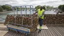 Seorang pekerja memindahkan gembok cinta di Jembatan Pont des Arts di atas Sungai Seine, Paris, Perancis, Senin (1/6/2015). (REUTERS/Philippe Wojazer)