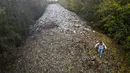 Rekaman dari pesawat tanpa awak atau drone mengungkap tumpukan sampah sepanjang lebih dari 60 meter, lebar sekitar 15 meter, dengan tinggi 10 meter. Tampak foto udara memperlihatkan aktivis lingkungan merekam konten untuk media sosial di tumpukan sampah ilegal yang besar, yang dibuang di sebuah ladang antara Sungai Cherwell dan Jalan A34 dekat Kidlington, Oxfordshire, di barat London pada 16 November 2025. (Justin TALLIS/AFP)