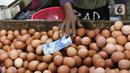 Pedagang telur ayam mengambil uang saat melayani pembeli di Pasar Kelapa Dua, Kabupaten Tangerang, Banten, Rabu (29/12/2021). Kementerian Perdagangan mencatat meroketnya harga telur ayam di sejumlah wilayah jelang pergantian tahun. (Liputan6.com/Angga Yuniar)
