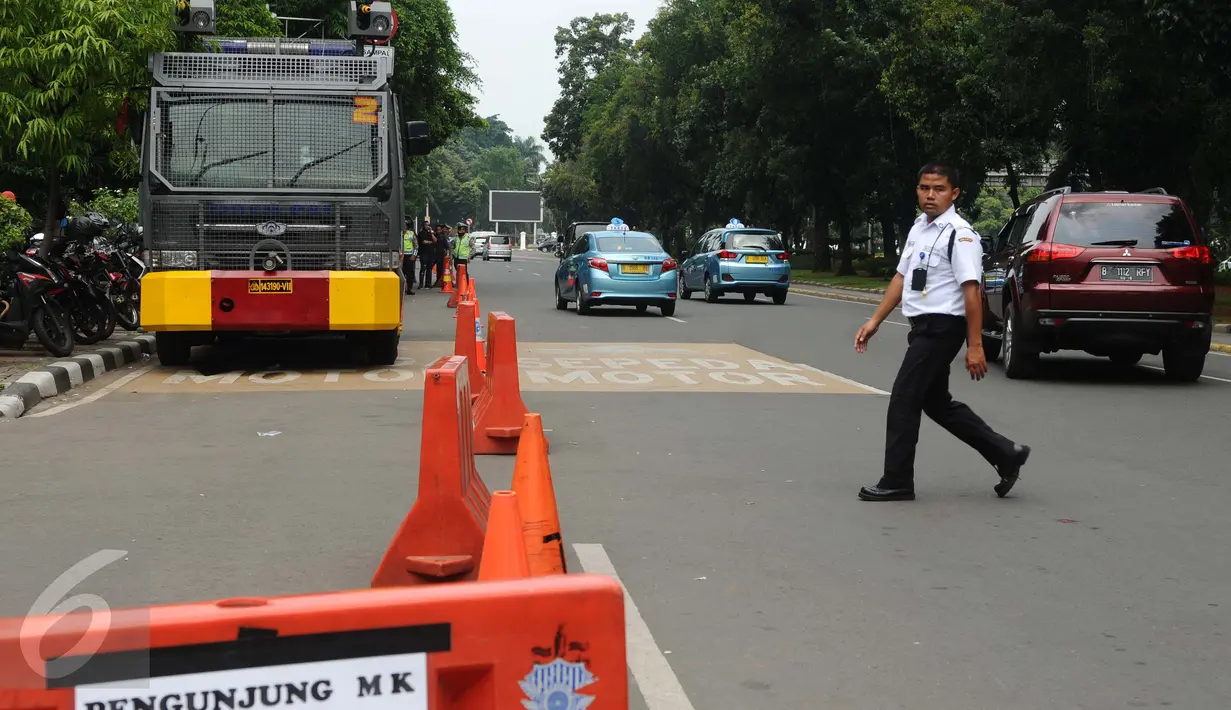 Kendaraan water cannon disiagakan di samping gedung Mahkamah Konstitusi, Jakarta, Senin (18/1/2016). Mahkamah Konstitusi membacakan 40 putusan perselisihan hasil Pilkada 2015 secara marathon pada Senin (18/1/2016). (Liputan6.com/Helmi Fithriansyah)