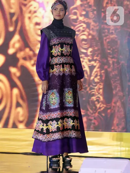 Seorang model berpose mengenakan busana rancangan Wignyo saat peragaan busana dalam gelaran Festival 6 2023 di Senayan Park, Jakarta, Minggu (9/7/2023). (Liputan6.com/Helmi Fithriansyah)